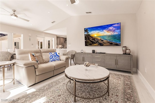 living room featuring light hardwood / wood-style floors, vaulted ceiling, and ceiling fan