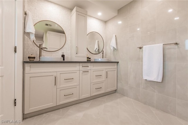 bathroom featuring tile walls, vanity, and backsplash