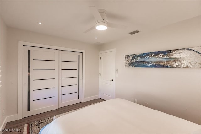 bedroom with ceiling fan, a closet, and dark hardwood / wood-style flooring