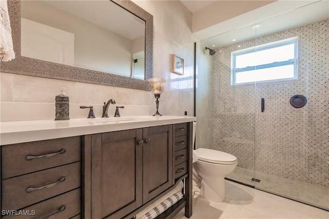 bathroom with toilet, vanity, a shower with shower door, and decorative backsplash