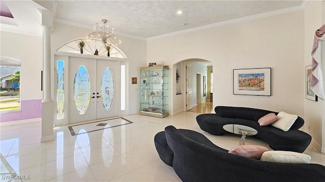 foyer entrance with ornamental molding and an inviting chandelier