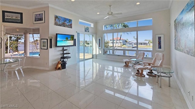 interior space with a high ceiling, crown molding, and ceiling fan