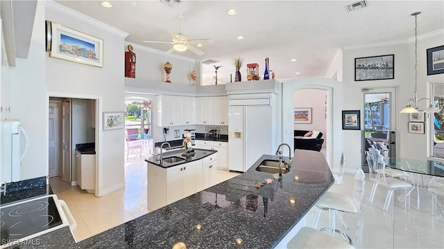 kitchen featuring white cabinetry, sink, crown molding, and paneled built in fridge