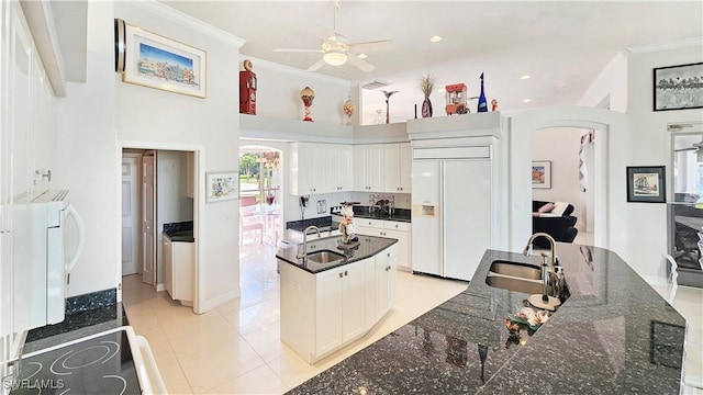 kitchen with white cabinetry, sink, a kitchen island, and paneled built in refrigerator