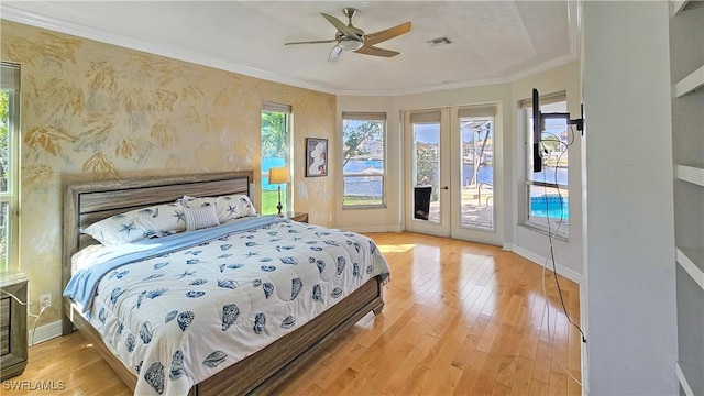 bedroom with multiple windows, ornamental molding, access to outside, and light hardwood / wood-style floors