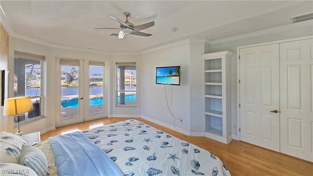 bedroom with french doors, ornamental molding, access to exterior, and light hardwood / wood-style floors