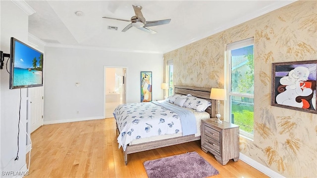 bedroom with crown molding, light hardwood / wood-style flooring, ceiling fan, and ensuite bathroom