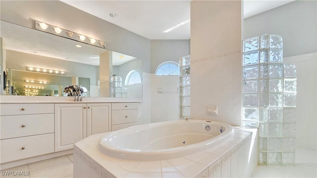 bathroom featuring tile patterned floors, vanity, and tiled tub