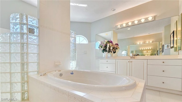 bathroom featuring vanity, tile patterned flooring, and tiled bath