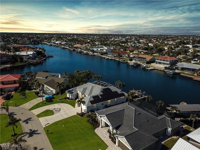 aerial view at dusk featuring a water view