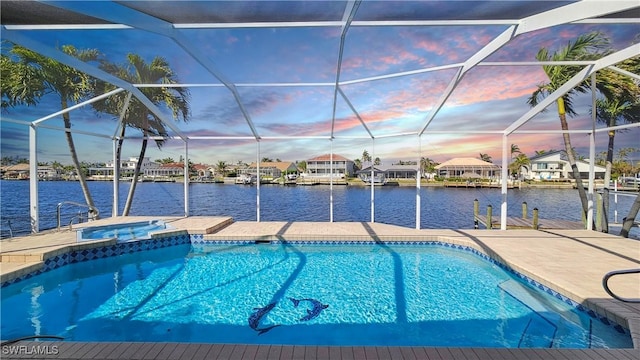 pool at dusk with an in ground hot tub, a water view, a dock, and glass enclosure