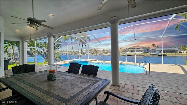 patio terrace at dusk featuring a water view, ceiling fan, a lanai, and a pool with hot tub