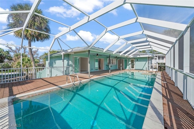 view of swimming pool featuring a patio, ceiling fan, and glass enclosure