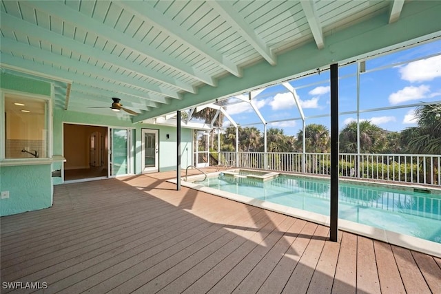 view of swimming pool featuring an in ground hot tub, ceiling fan, and glass enclosure