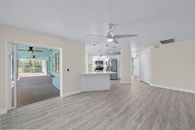 unfurnished living room featuring ceiling fan and light wood-type flooring