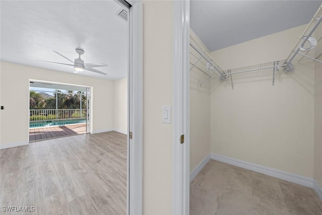 walk in closet featuring ceiling fan and light hardwood / wood-style flooring