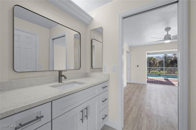 bathroom with hardwood / wood-style flooring, ceiling fan, and vanity