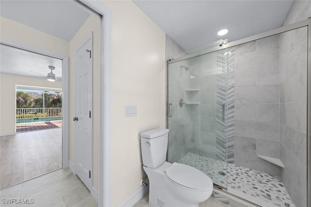 bathroom featuring ceiling fan, toilet, and an enclosed shower