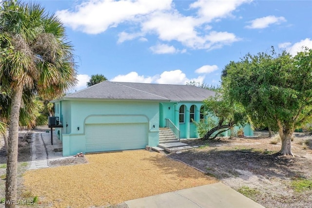 ranch-style home with a garage and central AC unit