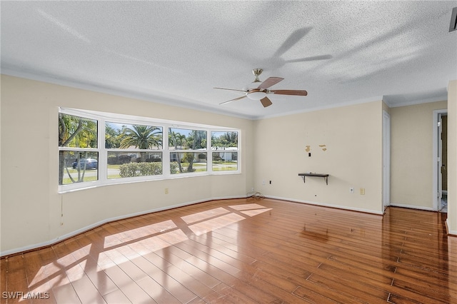 empty room featuring wood-type flooring, crown molding, and a textured ceiling