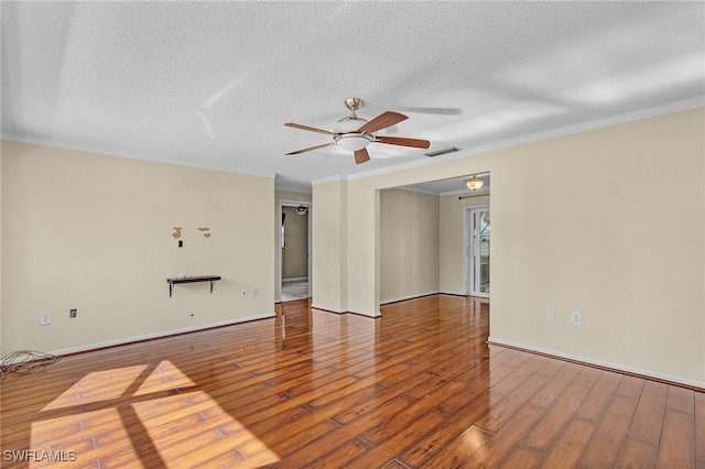 empty room featuring wood-type flooring, ornamental molding, ceiling fan, and a textured ceiling