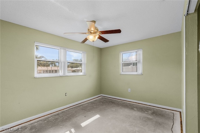 unfurnished room with ceiling fan, a healthy amount of sunlight, and a textured ceiling