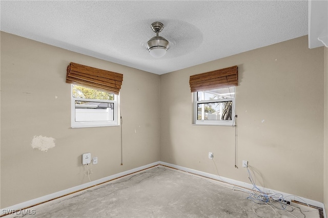 spare room featuring concrete flooring and a textured ceiling