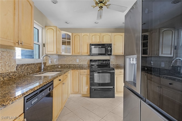 kitchen with light brown cabinetry, sink, black appliances, and dark stone counters