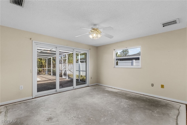 empty room featuring ceiling fan, concrete floors, and a textured ceiling