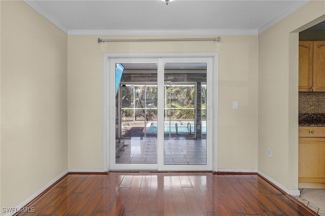 doorway to outside featuring ornamental molding, dark hardwood / wood-style flooring, and a textured ceiling