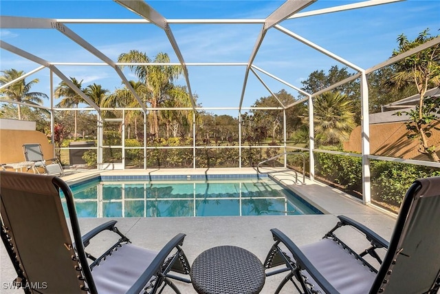 view of pool with glass enclosure and a patio area