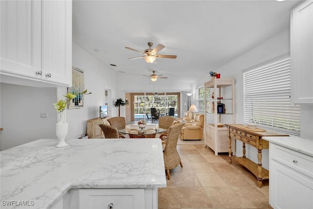 kitchen with ceiling fan and white cabinets