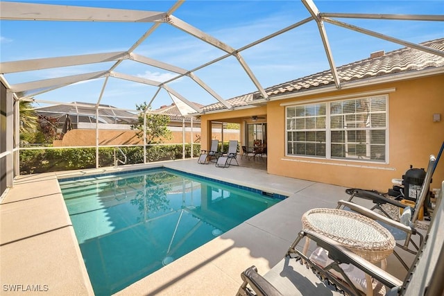 view of swimming pool featuring a patio, a lanai, and ceiling fan