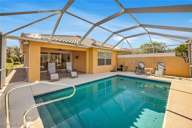 view of pool with ceiling fan, a patio, and glass enclosure