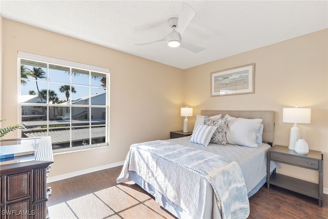 bedroom featuring a textured ceiling, dark wood-type flooring, and ceiling fan