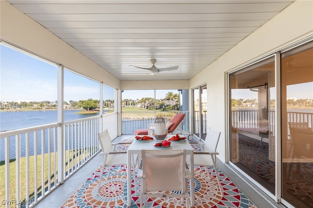 sunroom featuring a water view and ceiling fan