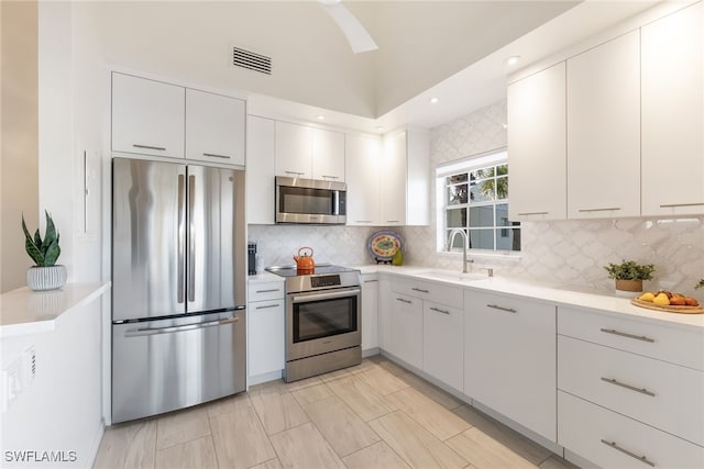 kitchen with white cabinetry, sink, tasteful backsplash, and stainless steel appliances