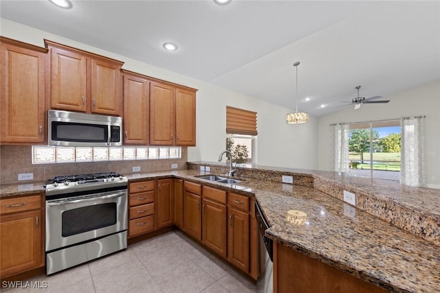 kitchen featuring sink, decorative light fixtures, dark stone countertops, stainless steel appliances, and decorative backsplash