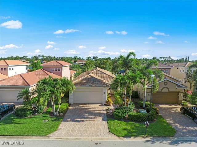 view of front of home with a garage, a tile roof, a residential view, and decorative driveway