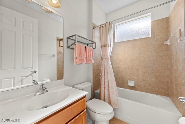 full bathroom featuring vanity, shower / bath combination with curtain, and toilet