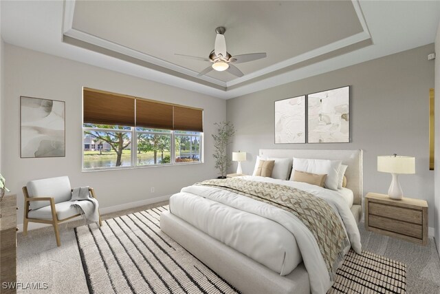 bedroom with a tray ceiling, ceiling fan, and carpet