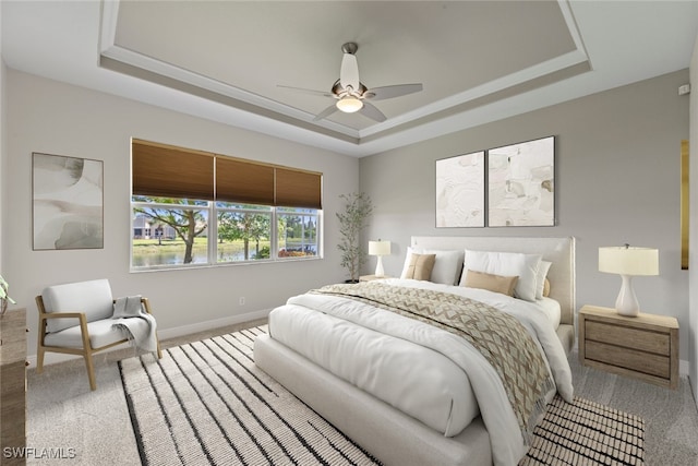 carpeted bedroom featuring ceiling fan, a tray ceiling, and baseboards