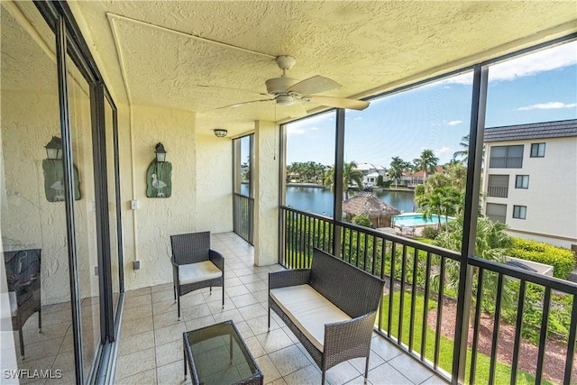 balcony with a water view and ceiling fan