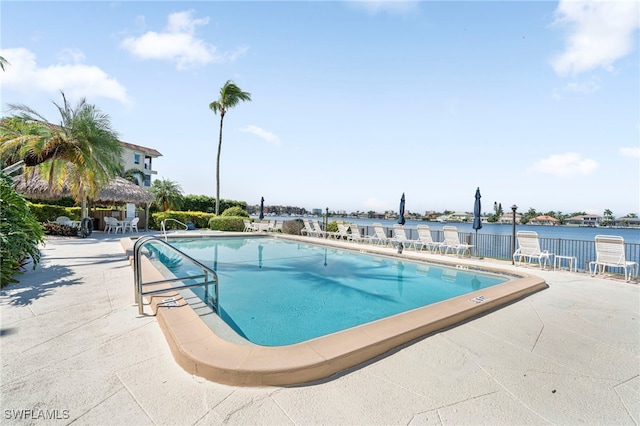 view of swimming pool with a water view and a patio