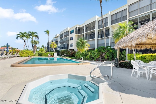 view of pool with a community hot tub and a patio