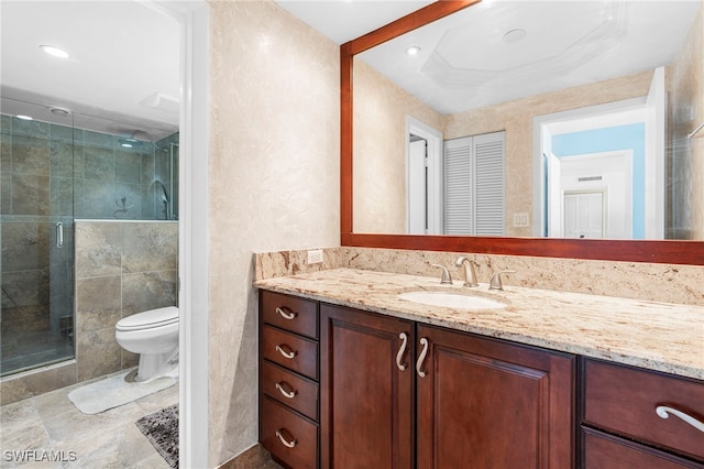 bathroom featuring vanity, an enclosed shower, and toilet