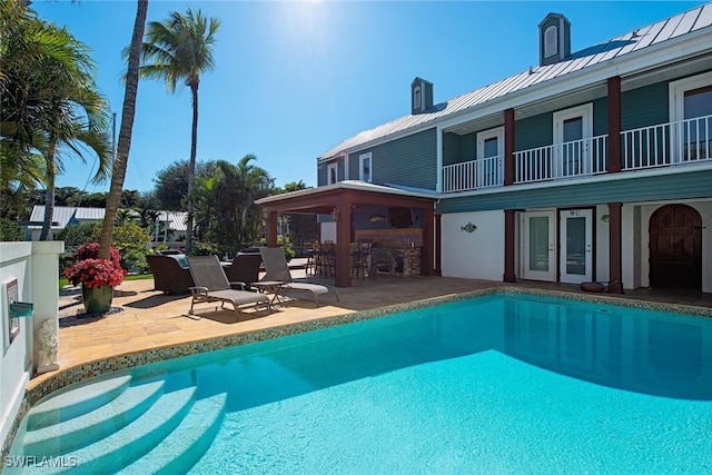 view of swimming pool with an outdoor bar and a patio area