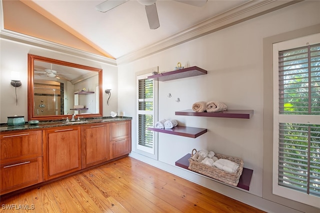 interior space featuring lofted ceiling, sink, crown molding, light wood-type flooring, and ceiling fan