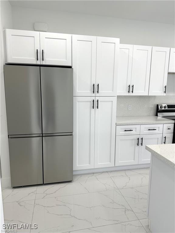 kitchen featuring white cabinetry, backsplash, and stainless steel appliances