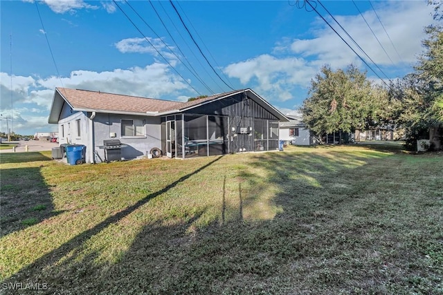 back of house featuring a yard and a sunroom